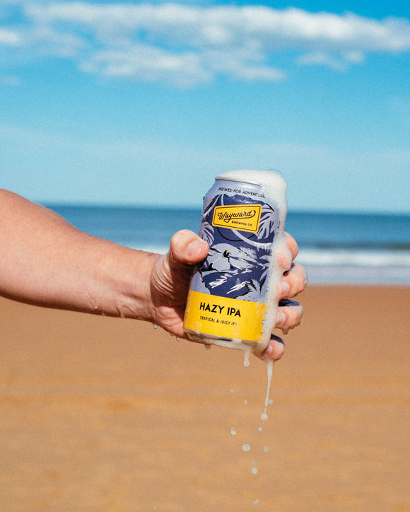 Hazy IPA can overflowing at the beach